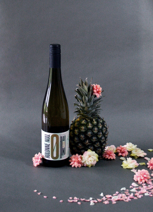 Bottle of Kolonne Null Sauvignon Blanc White Wine styled with flowers and a pineapple.